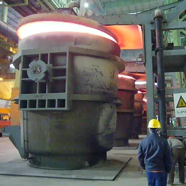 Hot steel ladle inside a steel plant during preheating or operation, showing refractory-lined ladle equipment and industrial furnace area